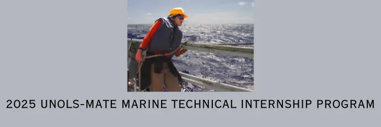 Person leaning on a ship's rail wearing a life jacket and hard hat with the background of a gray sea